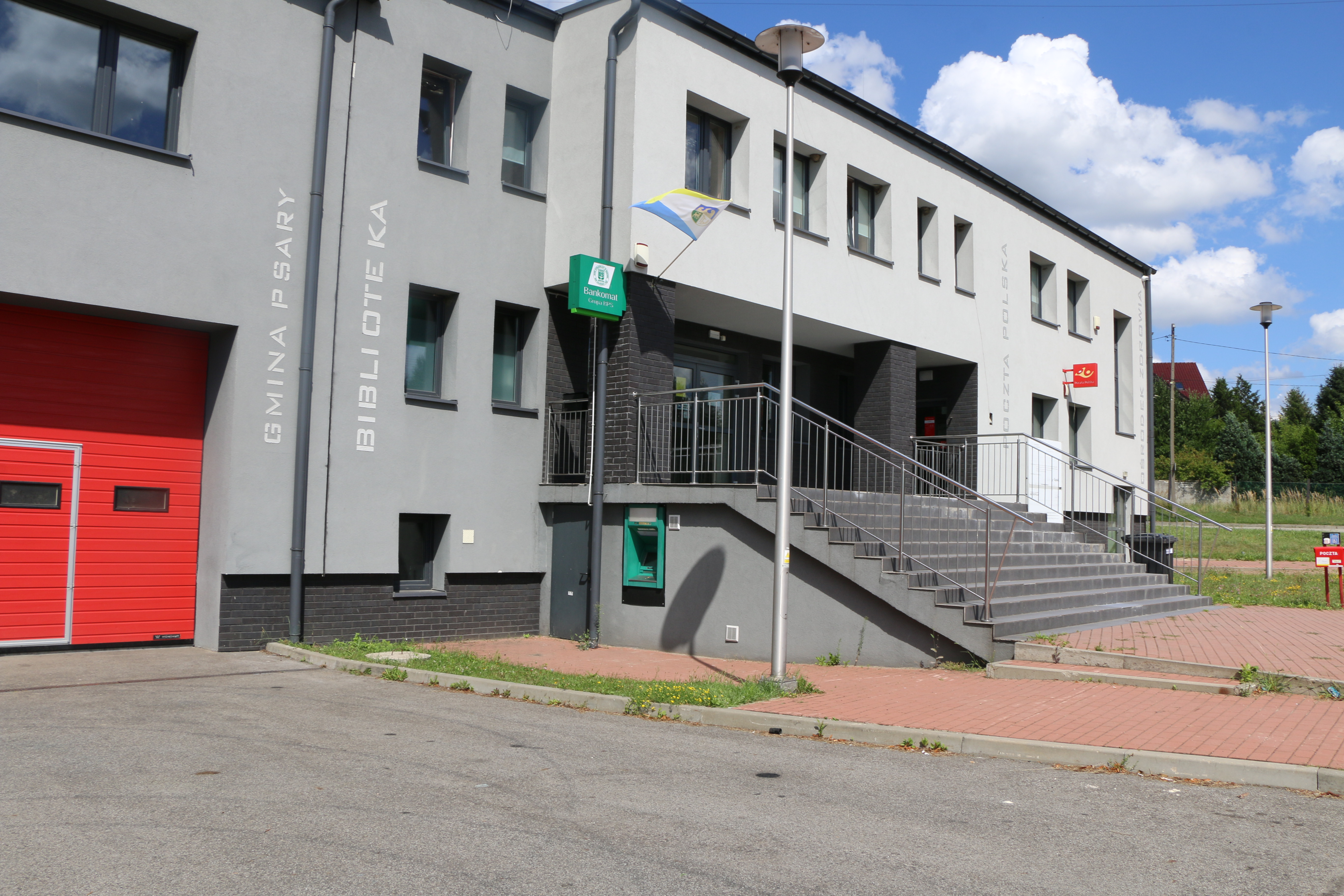 Na zdjęciu znajduje się budynek Centrum Usług społecznych w strzyżowicach oraz bankomat z Banku Spółdzielczego w Będzinie.